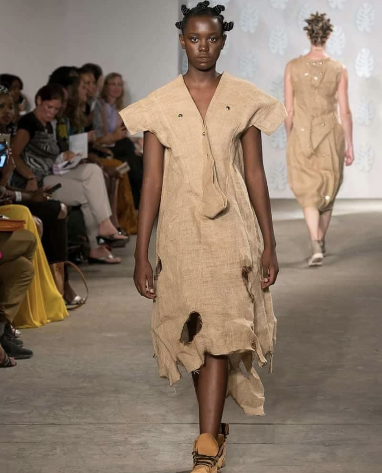 Bobbin Case model in a draped sisal sack dress with raw frayed hem on the runway — womenswear collection